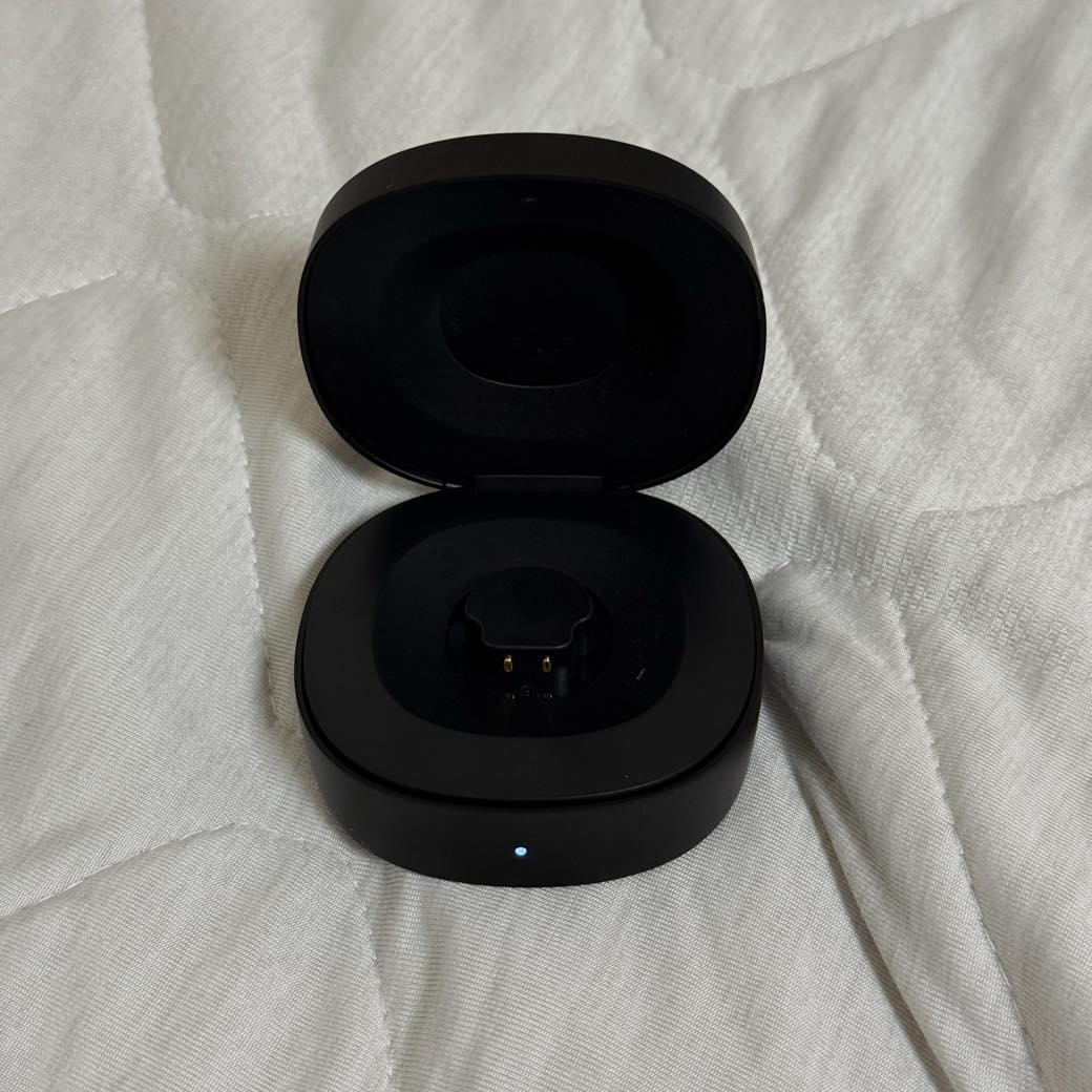 RingConn Gen 2 の充電ケースを開けた状態。中央に充電用の接点、手前に青いインジケーターが点灯している