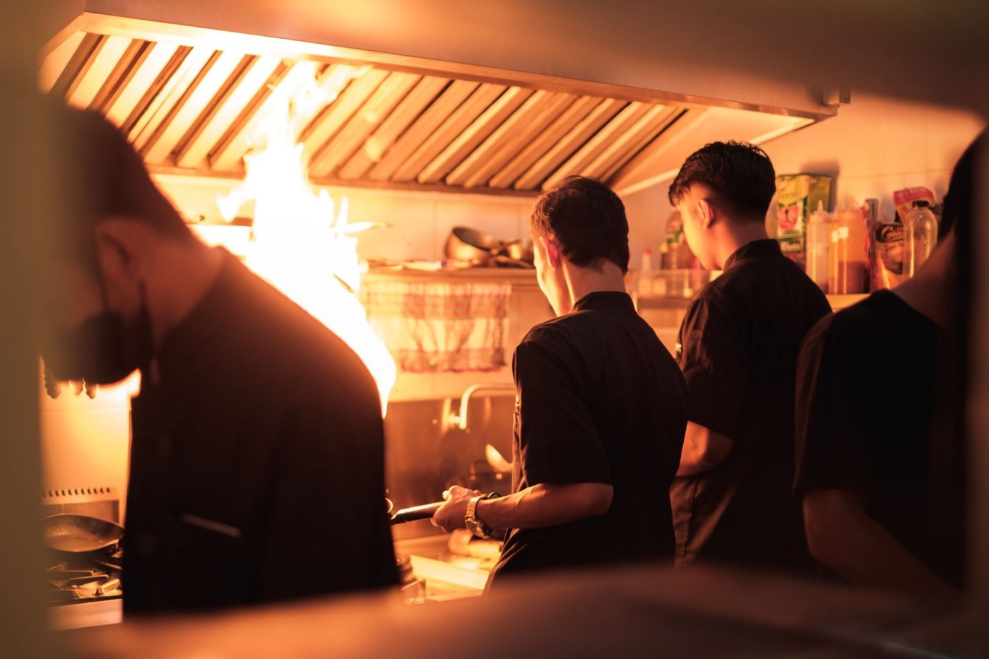 厨房で調理する飲食店のスタッフ